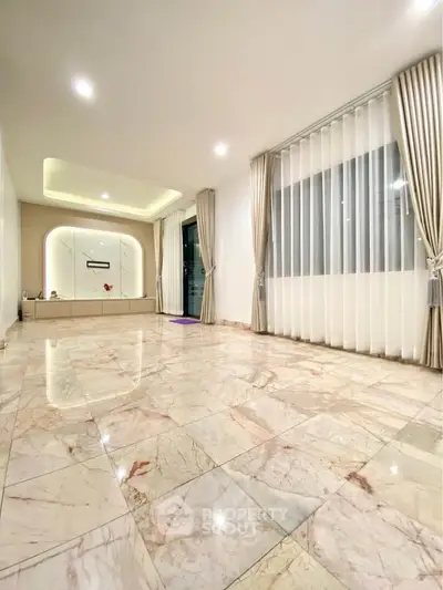 Spacious marble-floored living room with elegant curtains and modern lighting