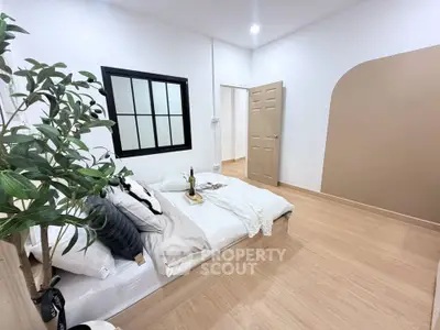 Cozy bedroom with modern decor and natural light, featuring a stylish bed and elegant wooden flooring.