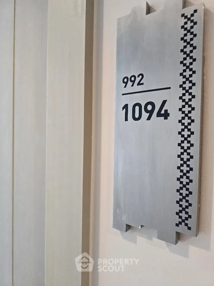 Modern apartment door number sign with sleek design and metallic finish