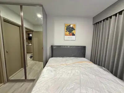 Modern bedroom with mirrored wardrobe and stylish decor in a cozy apartment.