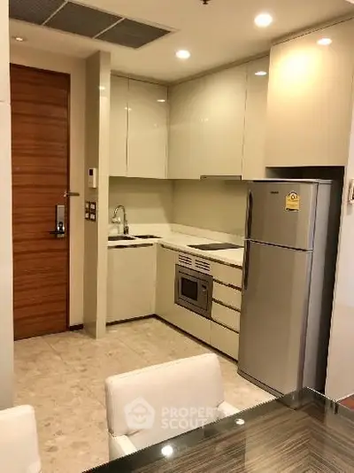 Modern kitchen with sleek cabinetry and stainless steel appliances in a compact layout.