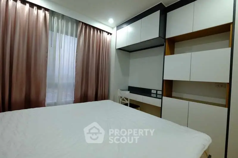 Modern bedroom with sleek built-in storage and elegant curtains