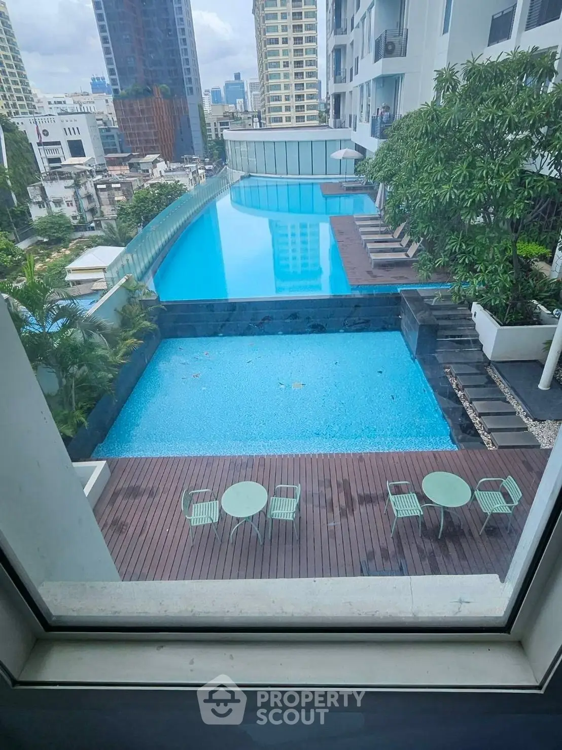 Luxurious high-rise pool view with modern cityscape backdrop, perfect for urban living enthusiasts.