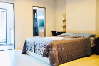 Spacious bedroom with modern decor and ensuite bathroom in a stylish apartment.