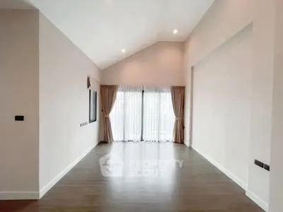 Spacious empty living room with high ceiling and large windows, perfect for customization.