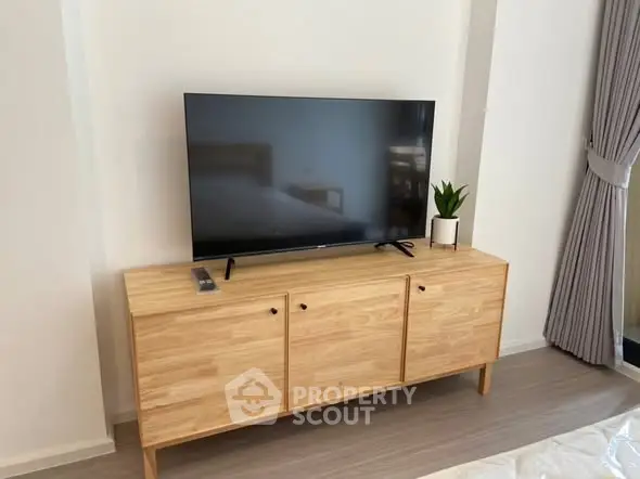 Modern living room with sleek TV on wooden cabinet and stylish decor