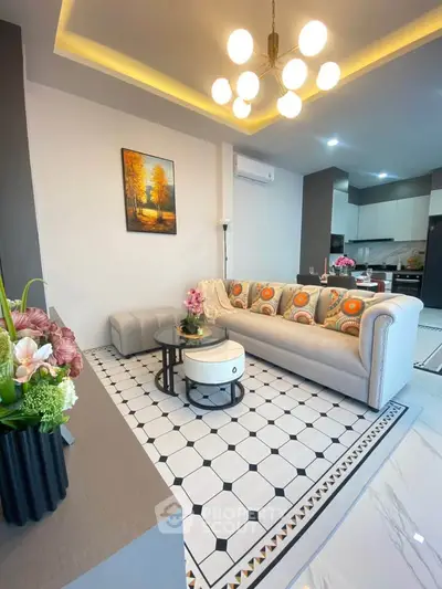 Stylish modern living room with elegant decor and open kitchen layout.