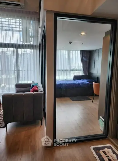 Modern apartment with glass partition, cozy living room and stylish bedroom.