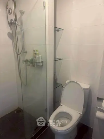 Modern bathroom with glass shower and sleek white tiles