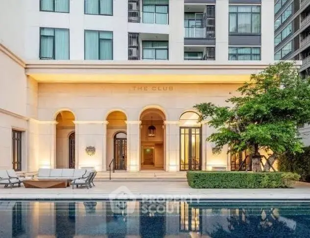 Luxurious residential building with elegant poolside and lush greenery.