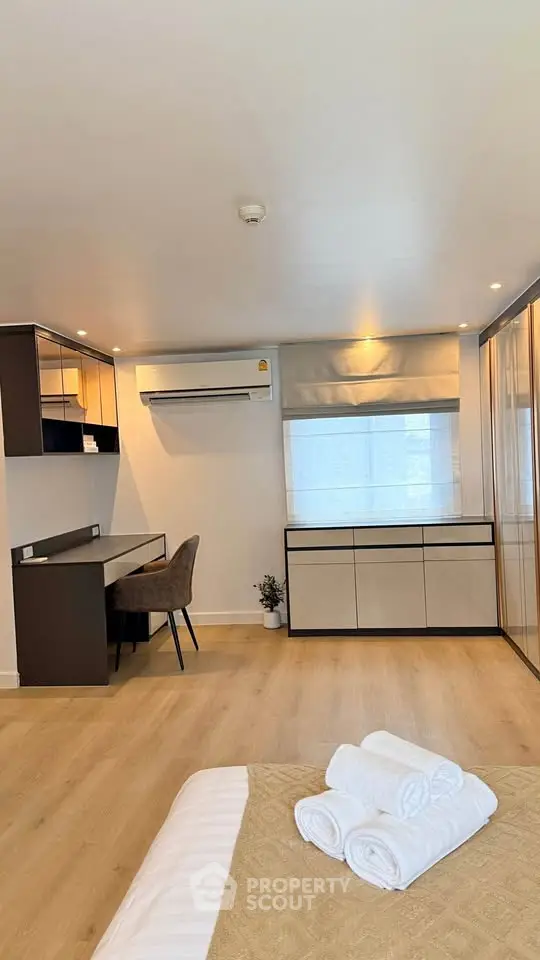 Modern bedroom with sleek design, featuring a study area and ample natural light.