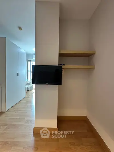 Modern apartment interior with wooden floors and wall-mounted TV