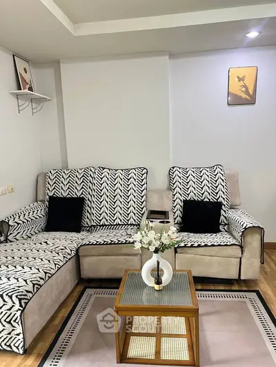 Stylish living room with patterned sofa and elegant decor, perfect for modern living.