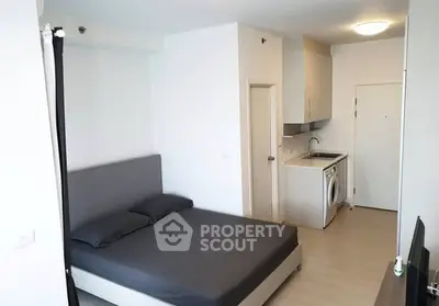 Modern studio apartment with compact kitchen and washing machine