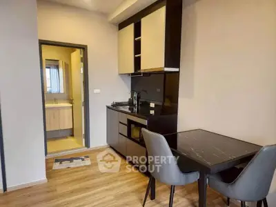 Modern kitchen with sleek black cabinets and dining area in stylish apartment