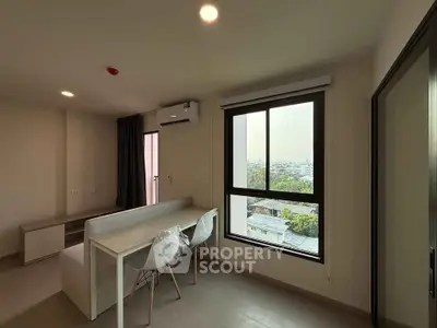 Modern apartment interior with large window and city view, featuring a dining area and air conditioning.