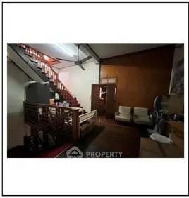 Spacious living area with wooden staircase and cozy seating
