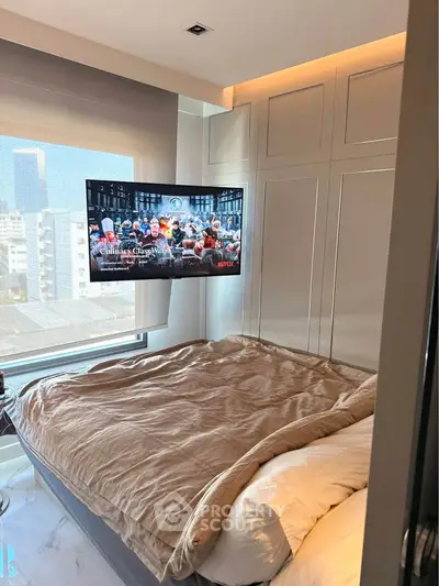 Modern bedroom with wall-mounted TV and city view from window