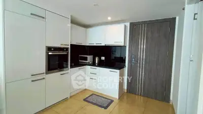 Modern kitchen with sleek cabinetry and built-in appliances in a contemporary apartment.