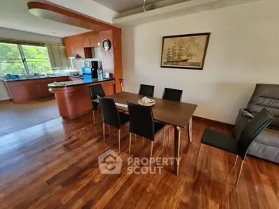 Spacious dining area with wooden flooring and modern kitchen in open layout