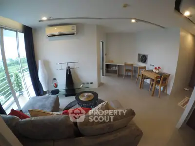 Modern living room with cozy sofa and dining area, featuring large windows and stylish decor.