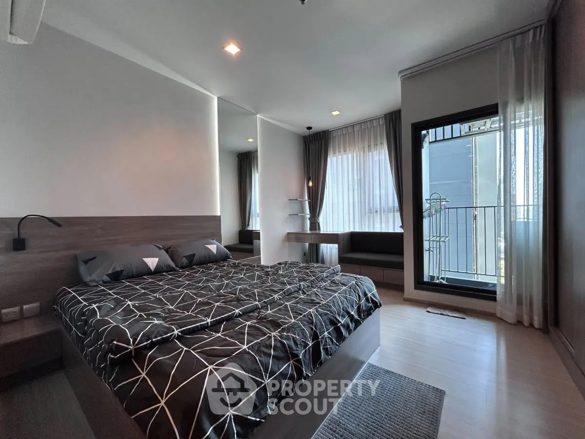 Modern bedroom with stylish decor and balcony access in a contemporary apartment.