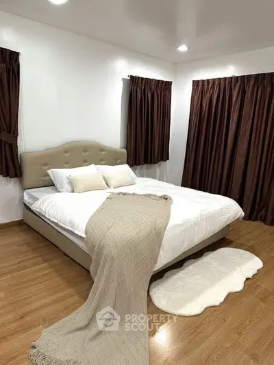 Spacious bedroom with elegant decor and cozy ambiance, featuring a plush bed and stylish curtains.