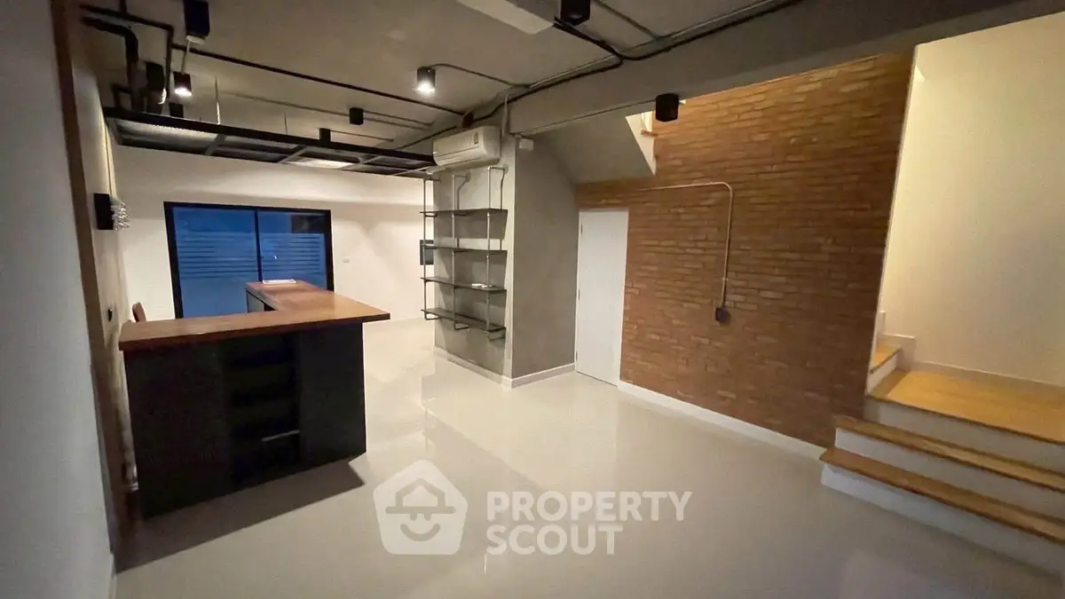 Modern industrial-style interior with open layout and brick accent wall