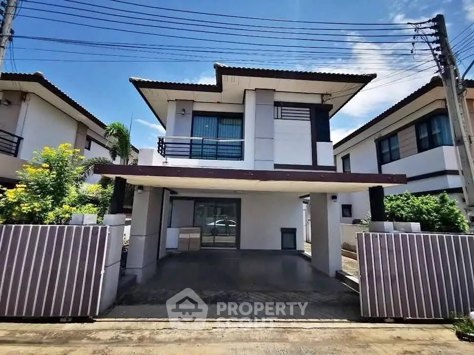 Modern two-story house with sleek design and spacious driveway in a suburban neighborhood.