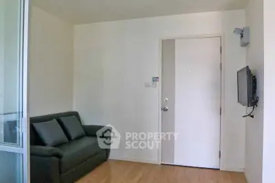 Cozy living room with modern sofa and wall-mounted TV, perfect for relaxation.