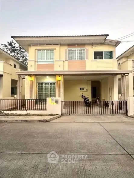 Charming two-story house with gated driveway and modern facade