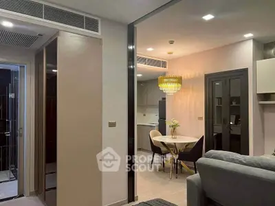Modern open-plan living and dining area with elegant lighting and contemporary furnishings.