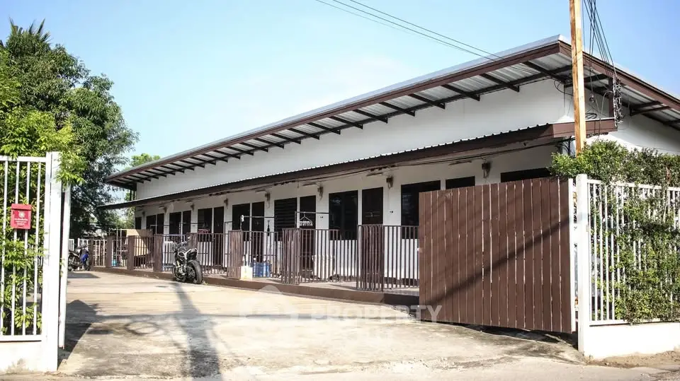 Charming single-story building with gated entrance and spacious driveway.