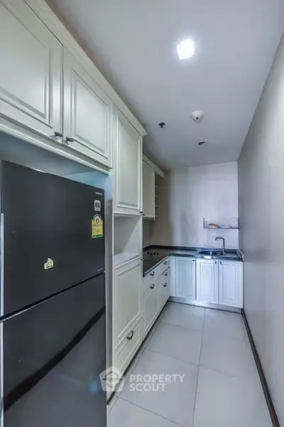 Modern kitchen with sleek cabinetry and stainless steel appliances in a compact layout.
