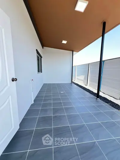 Spacious tiled outdoor area with modern design and ample natural light, perfect for relaxation or entertainment.