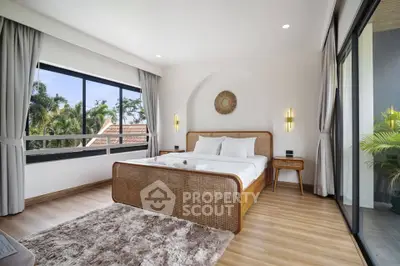 Luxurious bedroom with large windows and stylish decor in tropical setting