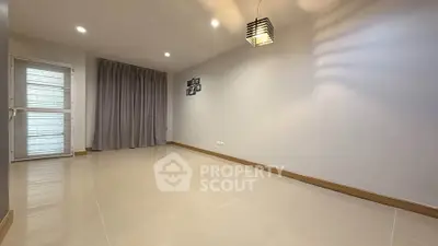 Spacious empty room with modern lighting and large window, perfect for customization.