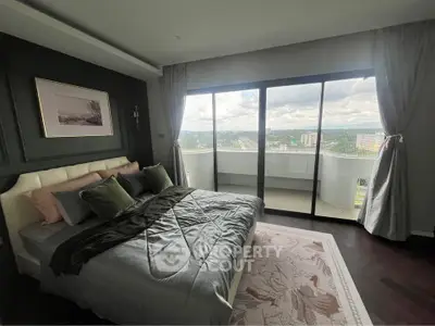 Luxurious bedroom with large windows and balcony offering stunning city views.