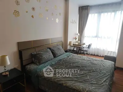 Elegant bedroom with stylish decor and natural light, featuring a cozy bed and work desk.