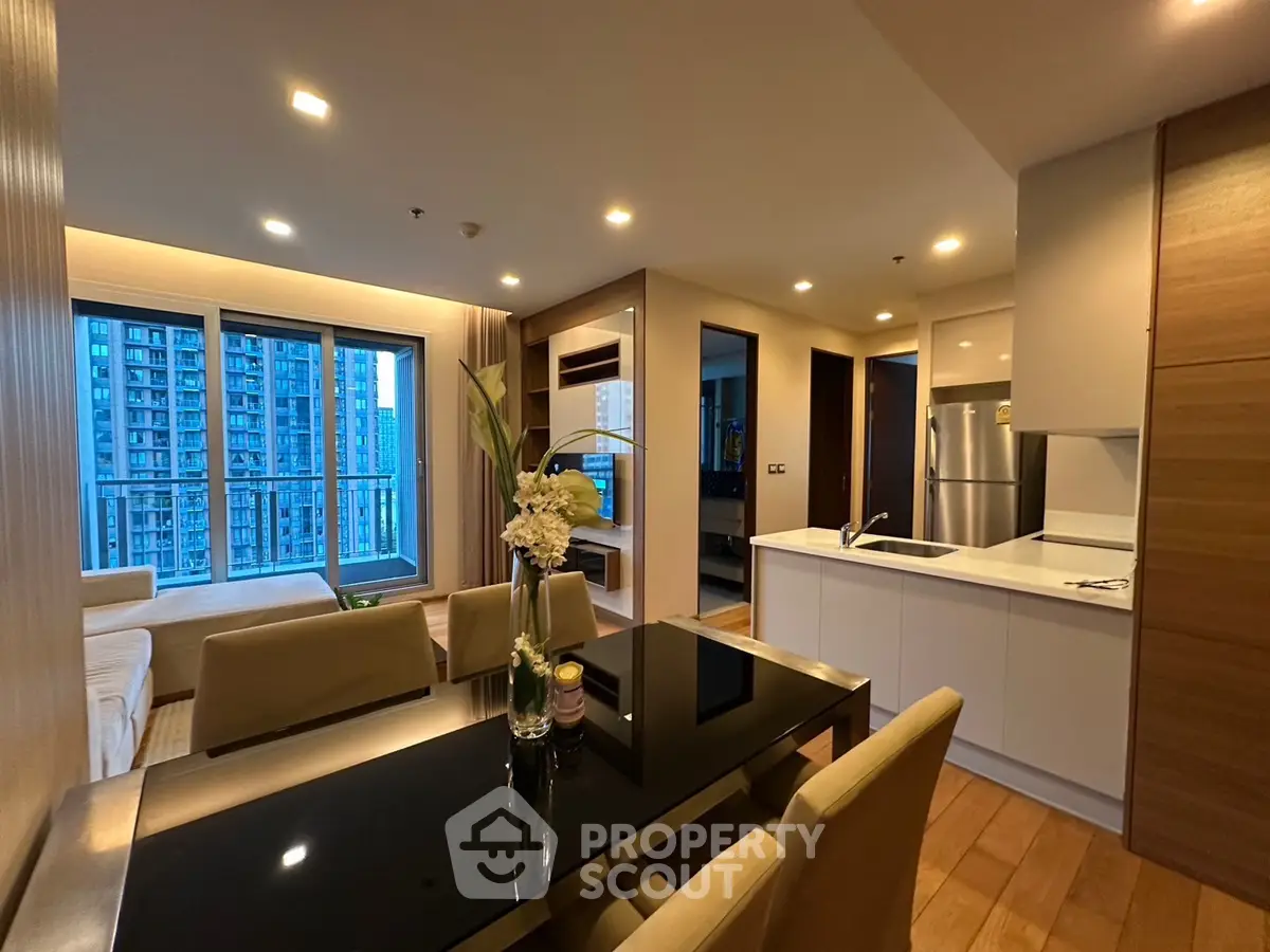 Modern open-layout living room with sleek kitchen and city view, perfect for urban living.