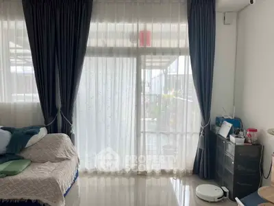 Cozy bedroom with large window and elegant curtains, featuring a comfortable bed and modern decor.