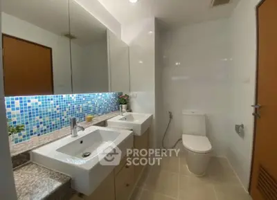 Modern bathroom with dual sinks and mosaic tile backsplash