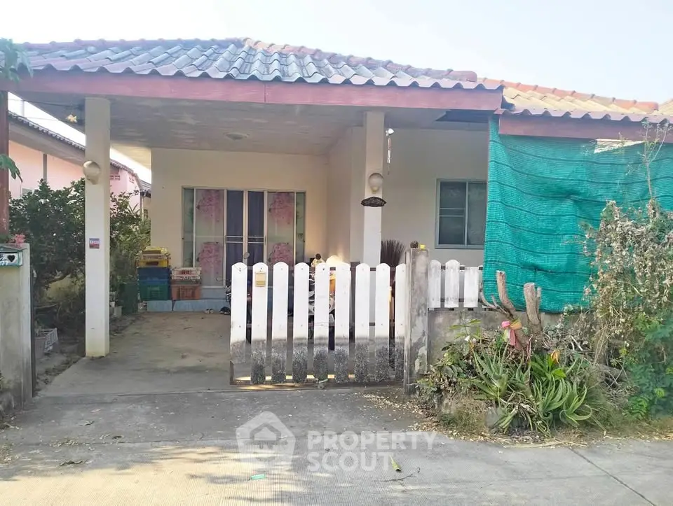 Charming single-story house with covered carport and small garden area.