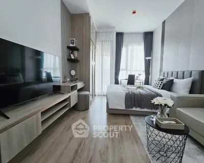 Modern bedroom with sleek design, featuring a large TV and elegant decor.
