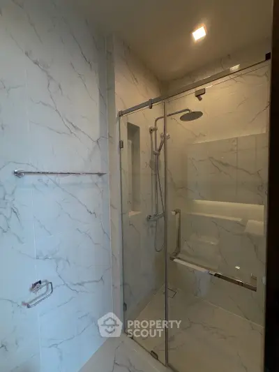 Luxurious modern bathroom with elegant marble tiles and glass shower enclosure