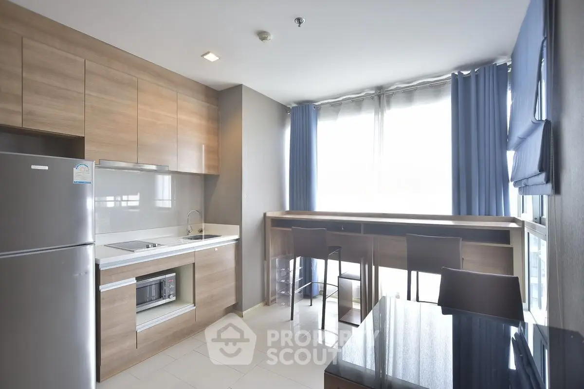 Modern kitchen with sleek wooden cabinets and large windows for natural light