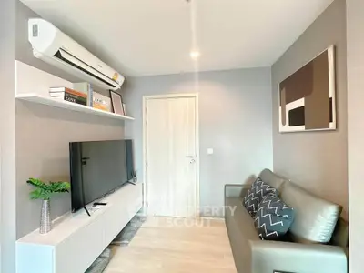 Modern living room with sleek furniture and wall-mounted TV, perfect for urban living.