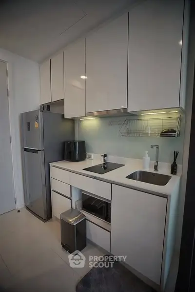 Modern kitchen with sleek cabinetry and stainless steel appliances in a compact layout.
