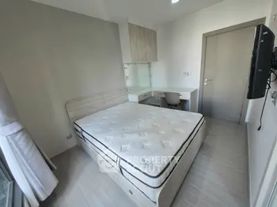 Modern bedroom with sleek design, featuring a comfortable bed and built-in desk area.