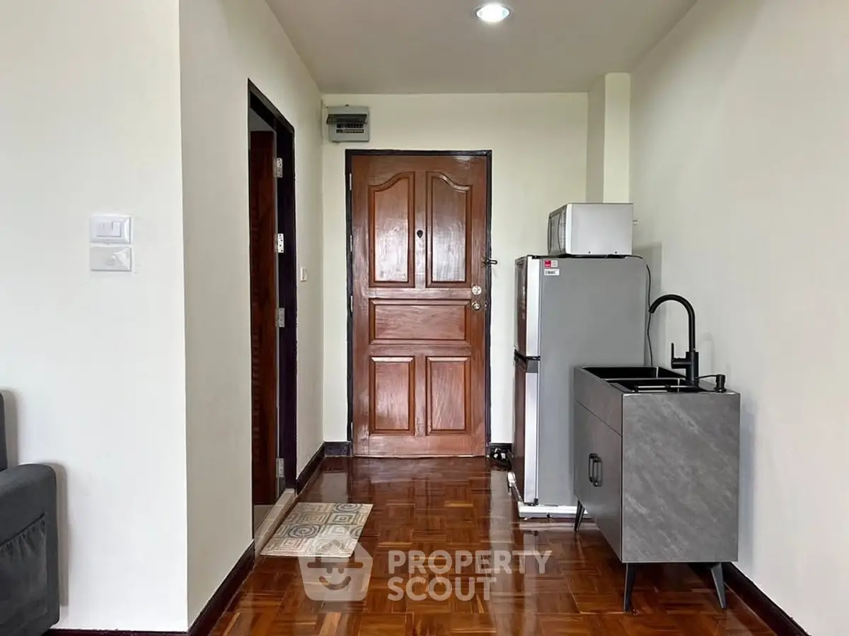 Cozy apartment entrance with compact kitchenette and wooden flooring